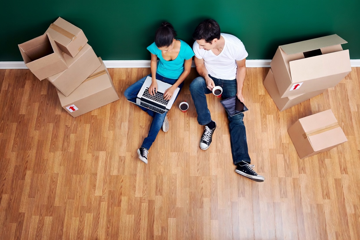 Couple reviewing mortgage options on a laptop in their new home